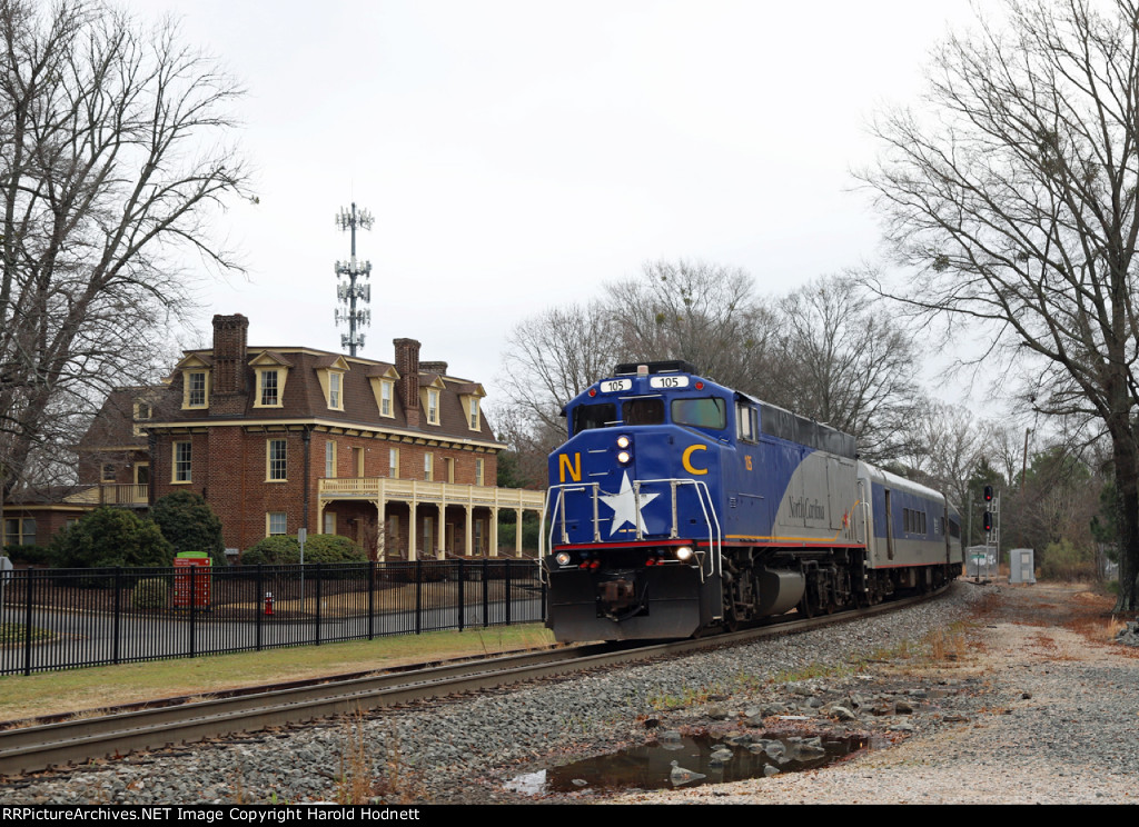 RNCX 105 leads train P073-26 past the historic Page-Walker hotel